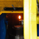 First, a robot places the glowing valve-to-be in a forging press.
