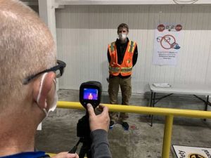Todd Haylett, facilities manager, has his temperature measured by George Sylvester, manufacturing engineering manager, at the General Motors assembly plant in Spring Hill on May 11.